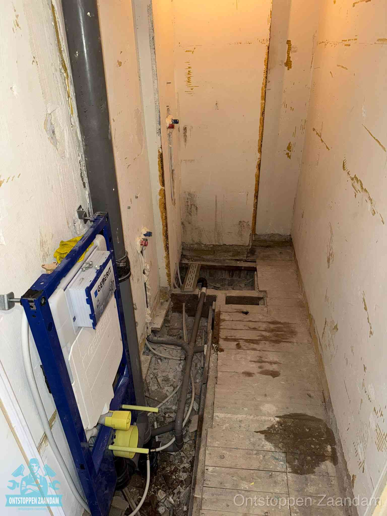 Een opgebroken toiletruimte tijdens renovatie met een Geberit inbouwreservoir en blootliggende oude afvoerleidingen, typisch voor oudere woningen in Zaandam